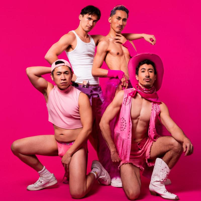 The performers pose in front of a pink background