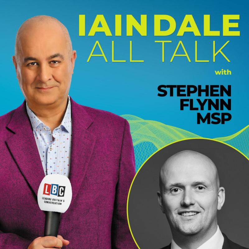 Host Iain Dale stares straight ahead with an LBC microphone wearing a purple blazer before a blue background. A photo of the guest in the bottom right corner.