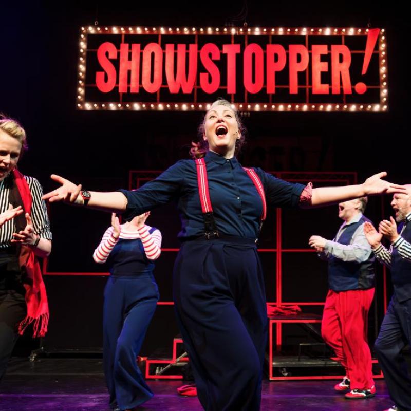Performers in front of 'Showstopper!' sign