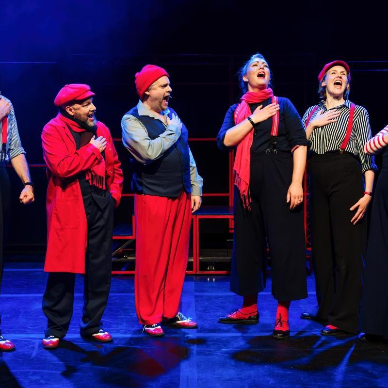 Photo showing performers with hands on their hearts whilst singing