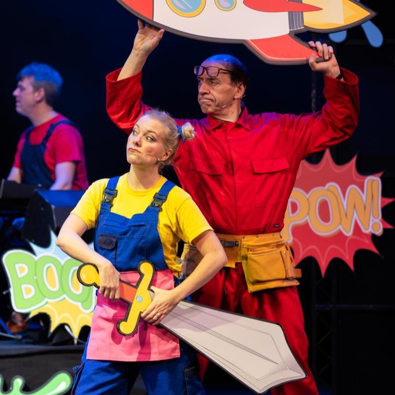 This photo shows two performers holding a cardboard rocket and sword