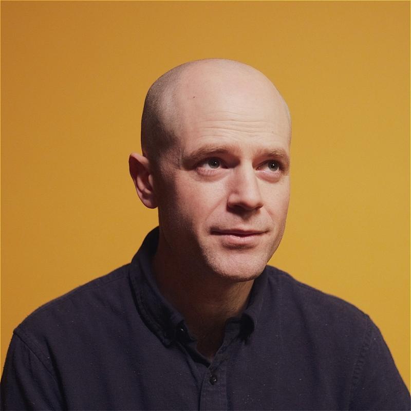 Photo of David Elms with a neutral expression looking up.