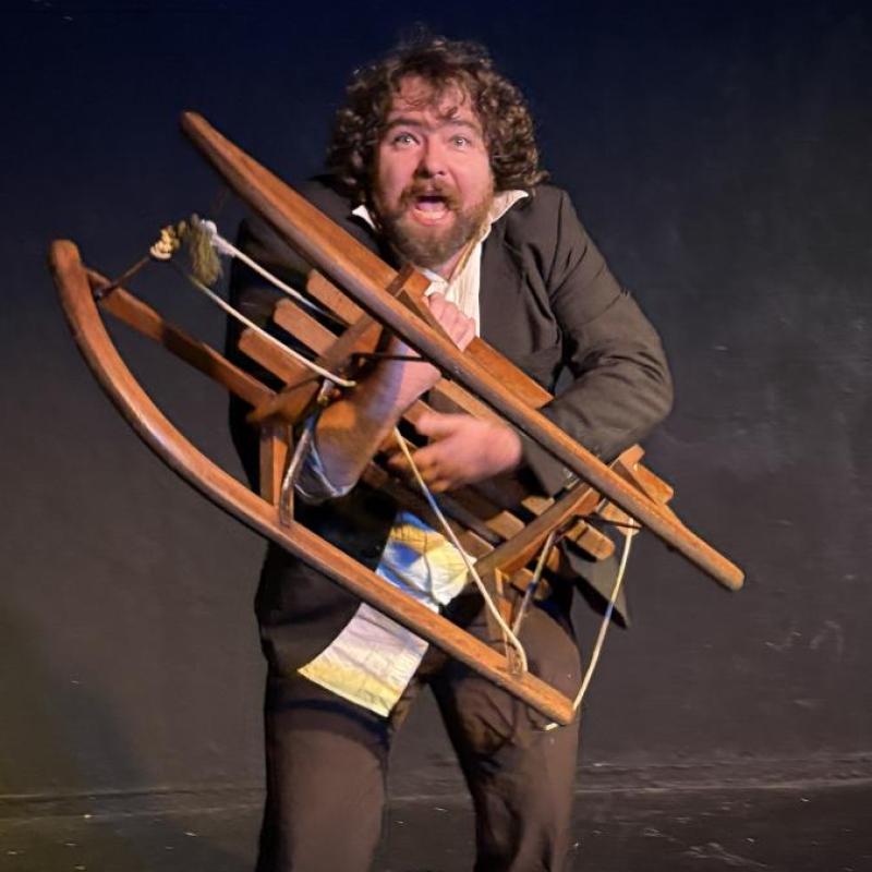 A hunch-backed servant clutches a wooden sledge