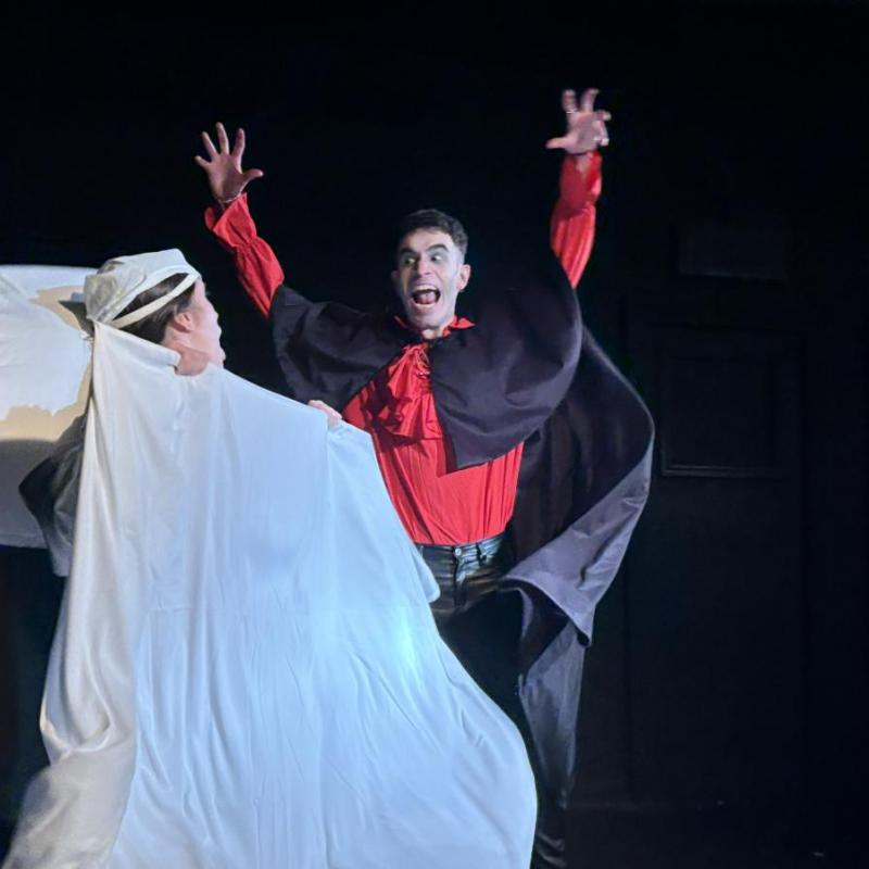 A vampire bares his teeth at a bed-bound man who notices and screams.