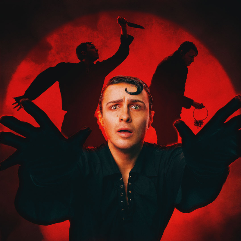 White man in black dress shirt and gloves reaches towards you with scared face and a curl in his hair. Background is a red spotlight with silhouette of two figures holding a knife and a set of keys.