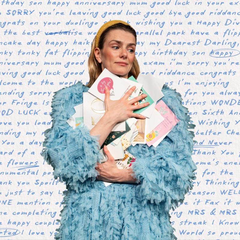 The performer clutches a pile of letters to their chest. Behind them is a large hand written letter with words circled and underlined.