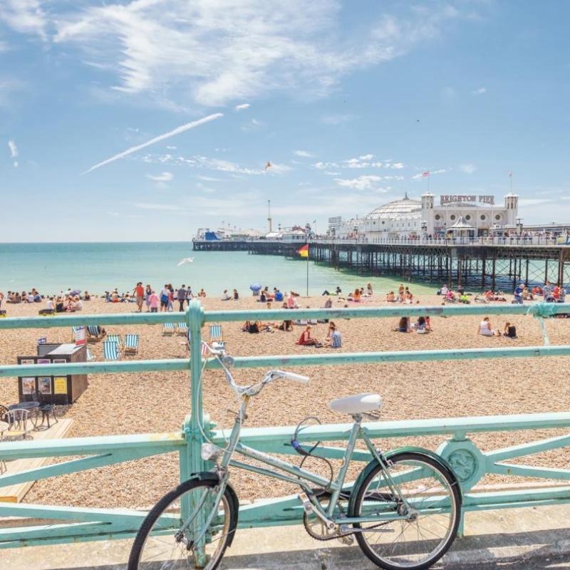 A sunny photograph of a bicycle on Brighton Beach.